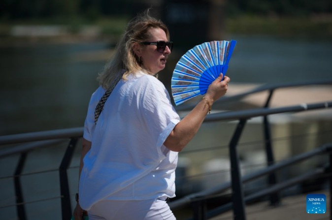 A woman uses a folding fan to cool down on June 28, 2026. Poland recorded the highest temperature ever on Sunday, surpassing a national record that has existed for more than a century. Photo: Xinhua