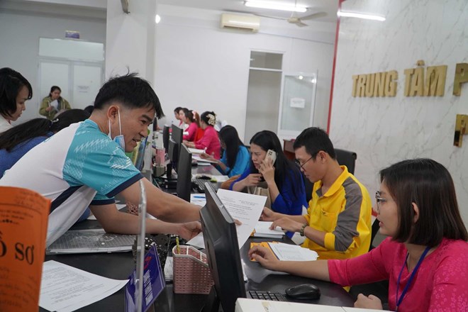 Cán bộ Trung tâm hành chính công phường Dĩ An (TPHCM) giải quyết hồ sơ cho người dân. Ảnh: Minh Quân