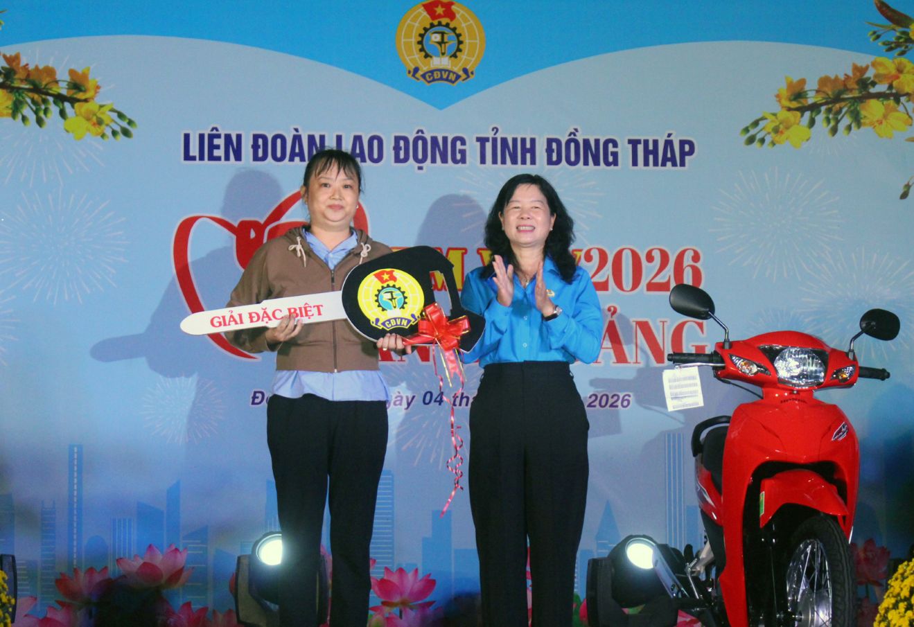 Chairman of Dong Thap Provincial Labor Federation Huynh Thi Tuyet Vui presents motorbike prizes to union members who draw prizes at the Tet Sum vay event. Photo: Thanh Mai