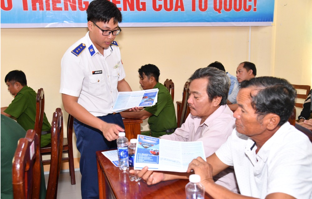Cán bộ Bộ Tư lệnh Vùng Cảnh sát biển 4 phát tờ rơi tuyên truyền cho ngư dân đặc khu Thổ Châu, tỉnh An Giang. Ảnh: Đức Thái