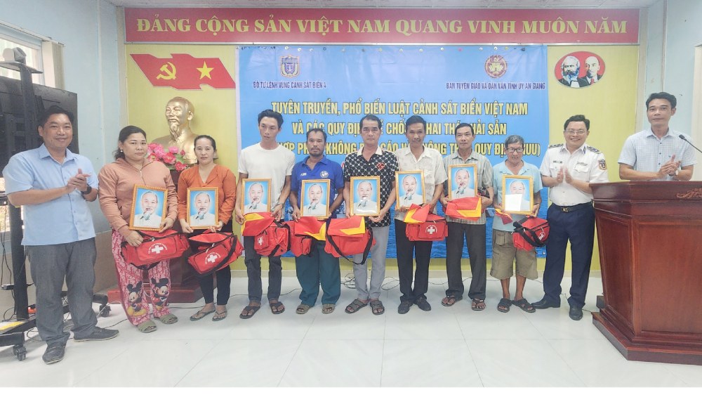Bộ Tư lệnh Vùng Cảnh sát biển 4 trao tặng cờ Tổ quốc, túi thuốc y tế và ảnh Bác Hồ cho bà con ngư dân trên địa bàn xã đảo Hòn Nghệ, tỉnh An Giang. Ảnh: Đức Thái