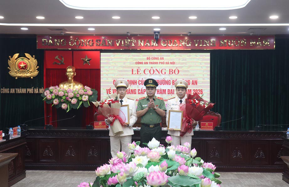Giám đốc Công an thành phố Hà Nội - Trung tướng Nguyễn Thanh Tùng trao Quyết định, tặng hoa chúc mừng hai đồng chí được thăng cấp bậc hàm Đại tá. Ảnh: Công an Hà Nội 


