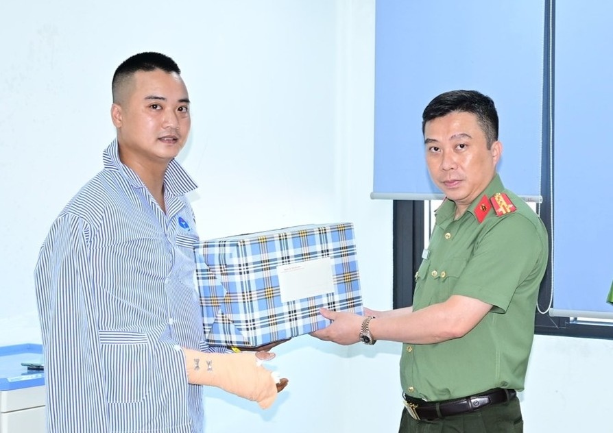 Colonel Le Trung Son - Deputy Director of the City Police visits, gives gifts, and encourages Captain Nguyen Duc Thinh. Photo: Hai Phong Police