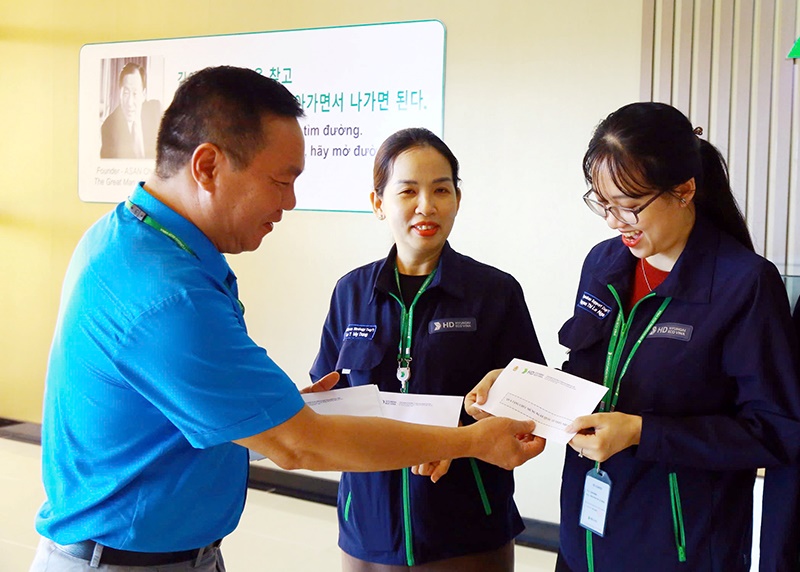 Mr. Ha Van Hung, Member of the Executive Committee of the Quang Ngai Provincial Labor Federation, Chairman of the grassroots Trade Union of HD Hyndai Eco Vina Company, presents gifts to the children's parents. Photo: Dang Khoi