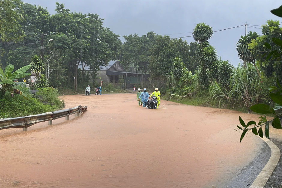 La policía de tráfico apoya a la gente y regula el tráfico durante las lluvias e inundaciones. Foto: Hà Thắng