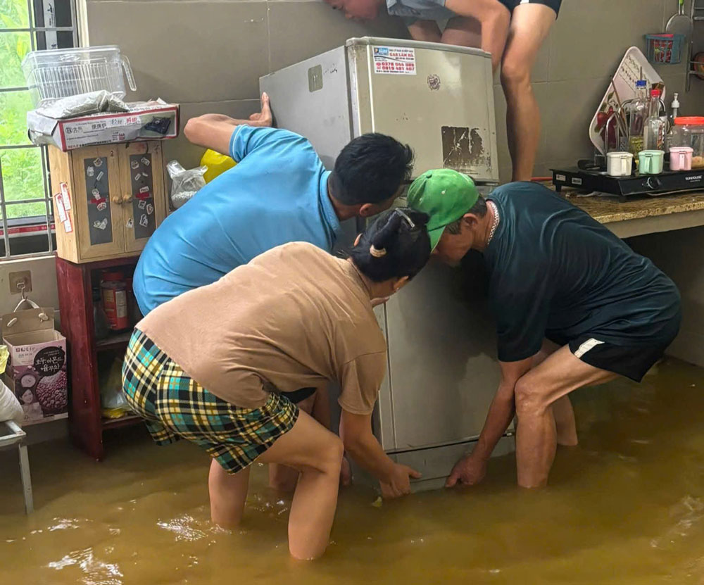 Người dân di chuyển đồ đạc, tài sản khỏi khu vực ngập nước. Ảnh: Hà Thắng
