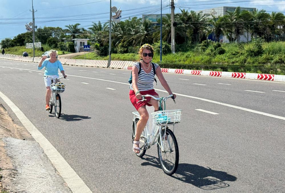 Du khách đạp xe đi dạo tuyến đường ven biển Mũi Né. Ảnh: Duy Tuấn 