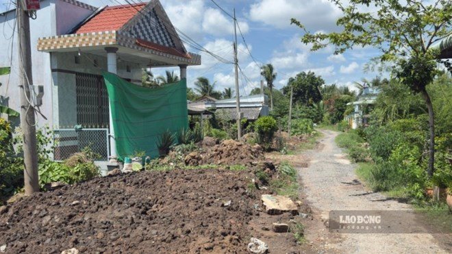 Soil and rocks are gathered haphazardly along the unfinished construction road, obstructing people's paths. Photo: Hoang Loc