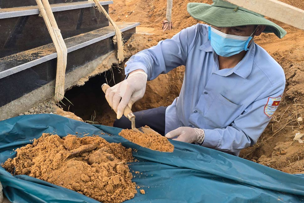 K52部隊(ザライ省軍事司令部)は、戦没者の墓から慎重に遺骨サンプルを採取しています。写真:ホアン・アイン