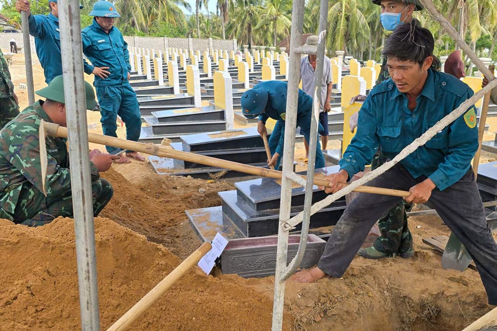 Lực lượng chức năng lấy mẫu hài cốt của các liệt sĩ. Ảnh: Hoàng Anh