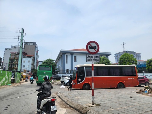 Mặc dù có biển cấp xe chở khách dừng đỗ nhưng nhiều nhà xe vẫn đỗ đón khách và hàng hoá tại phố Thiên Hiền, Hà Nội. Ảnh: Minh Hạnh