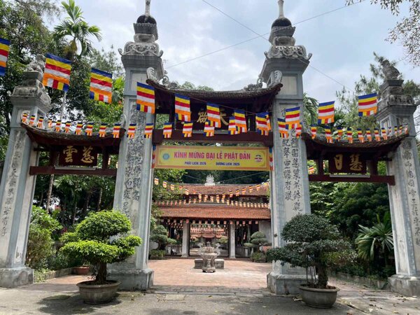 Cổng tam quan dẫn vào sân chùa có câu đối được ghép bằng những mảnh sứ màu xanh lam làm tăng thêm vẻ trang nghiêm cổ kính. Ảnh: I La
