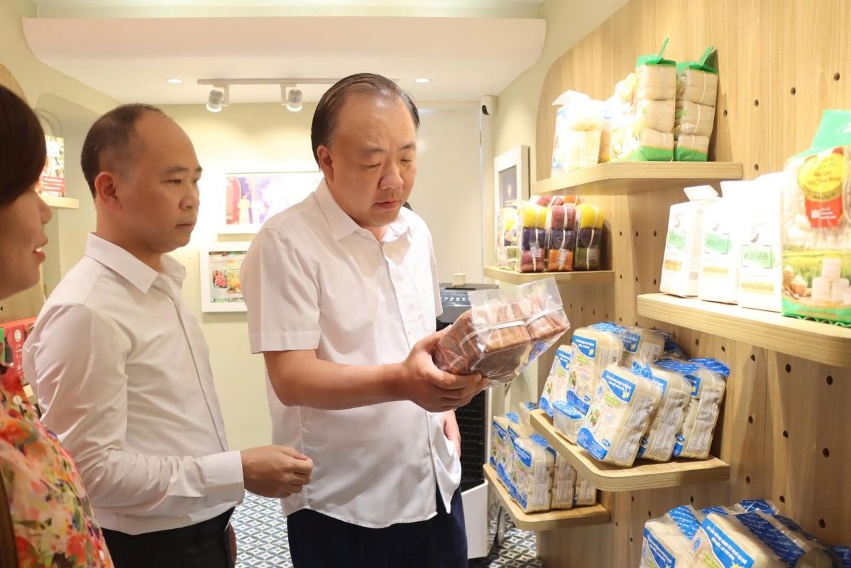 Ông Trần Hữu Linh, Cục trưởng Cục Quản lý và Phát triển thị trường trong nước và ông Nguyễn Thế Thi, Phó Giám đốc Sở Công Thương tỉnh Bắc Ninh tham quan gian hàng trưng bày, quảng bá vải thiều 