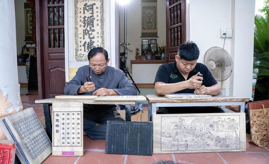 Young artisan Nguyen Cong Dat (right photo) chooses to stick with the Thanh Lieu woodblock printing profession. Photo: Character provided