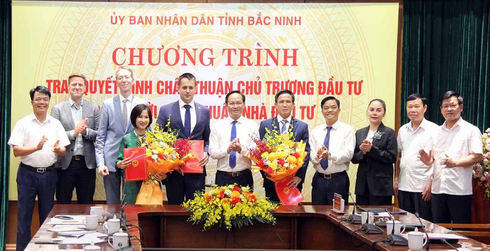 Vice Chairman of Bac Ninh Provincial People's Committee Pham Van Thinh presents the Investment Policy Approval Decision and presents flowers to congratulate investors. Photo: Thao My