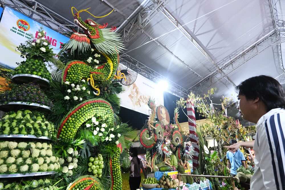 Fruits forming dragon and phoenix shapes, attracting many people to see