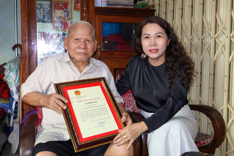 Chủ tịch UBND phường Quy Nhơn Nam Nguyễn Thị Bích Hoa chục thọ cụ Lê Quang Cựu (100 tuổi). Ảnh: Hoàng Nguyệt