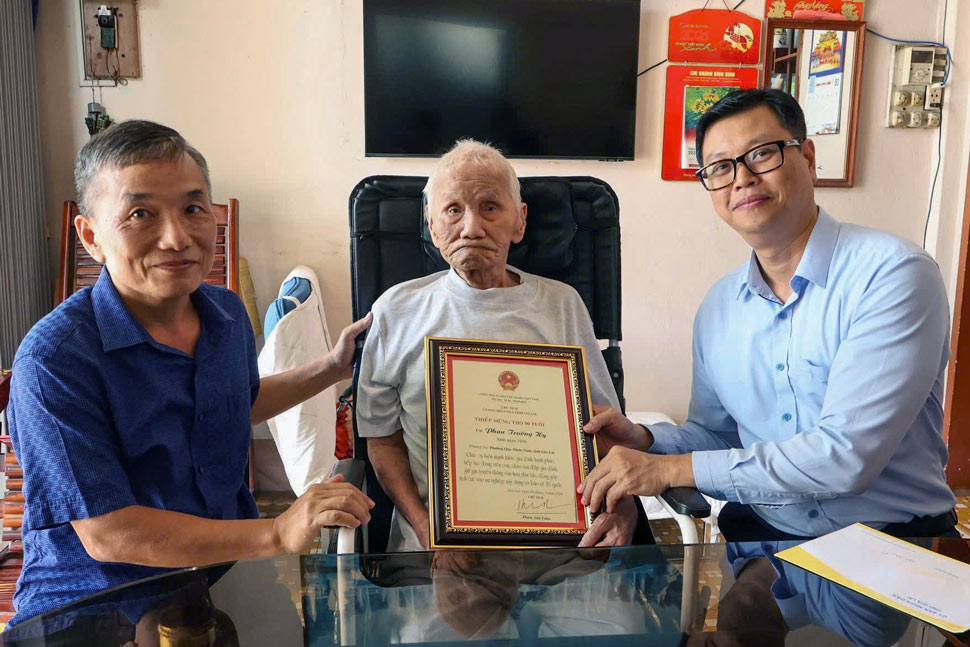 Bí thư Đảng ủy phường Quy Nhơn Nam Đặng Mạnh Cường chúc thọ cụ Phan Trường Hy (90 tuổi). Ảnh: Hoàng Nguyệt