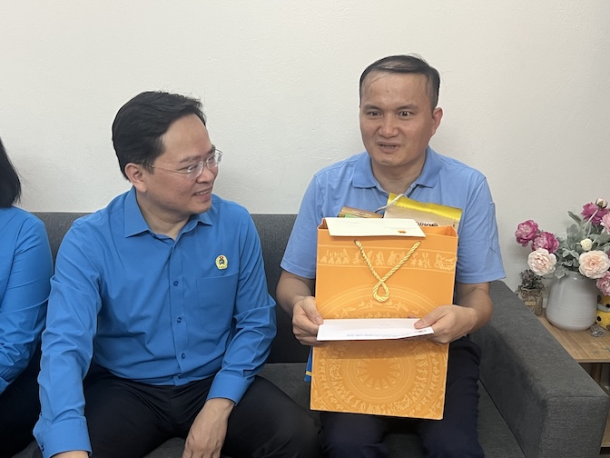 Chủ tịch Tổng Liên đoàn Lao động Việt Nam Nguyễn Anh Tuấn (bên trái) thăm, tặng quà anh Cao Văn Tuấn - Công nhân sản xuất - Công ty TNHH Nissei Electric Hà Nội. Ảnh: Kiều Vũ