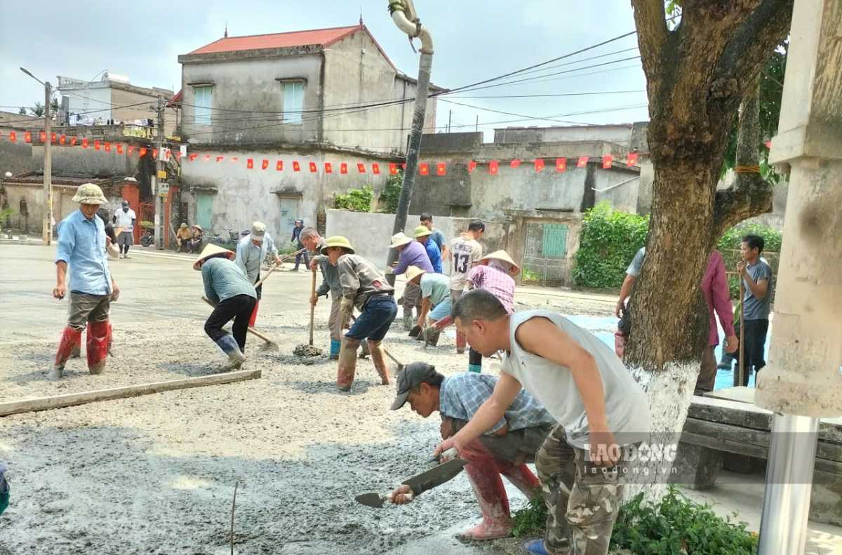La gente se une para verter hormigón y renovar el área del centro cultural de la aldea de Bái Phạm. Foto: Hà Vi