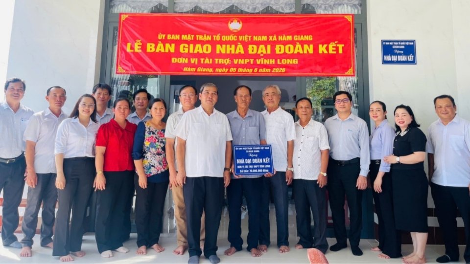 Les dirigeants de la province, du Front de la Patrie et des localités prennent des photos souvenirs avec les familles qui reçoivent une maison de grande solidarité. Photo: Front de la Patrie de la province de Vĩnh Long