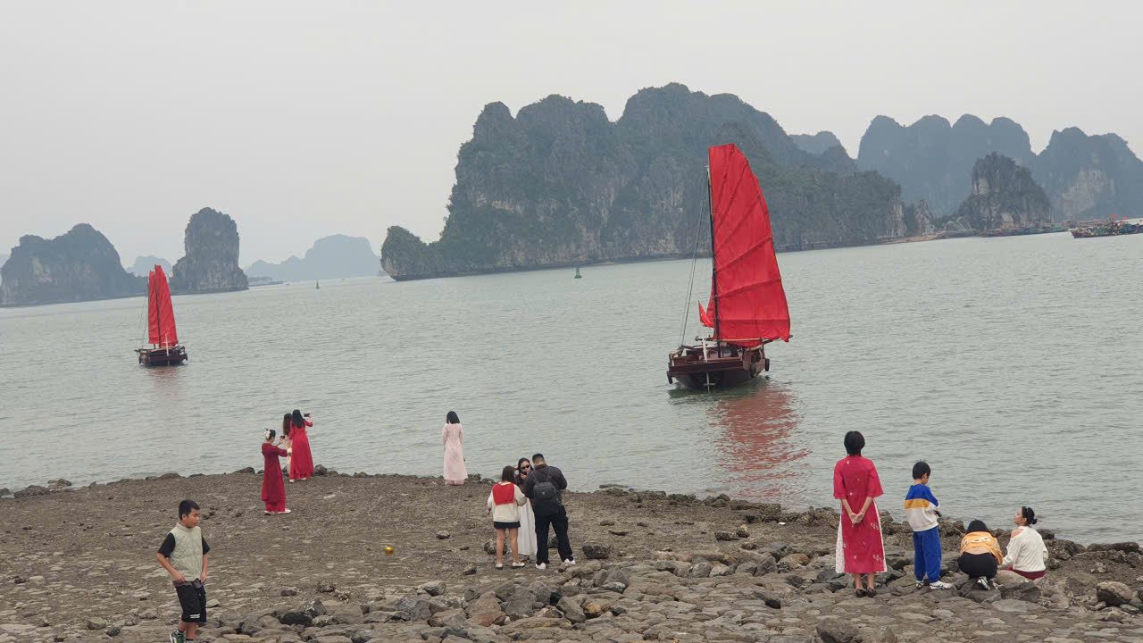 Người dân và du khách chụp ảnh cùng thuyền buồm ba vách bên bờ vịnh Hạ Long. Ảnh: Nguyễn Hùng