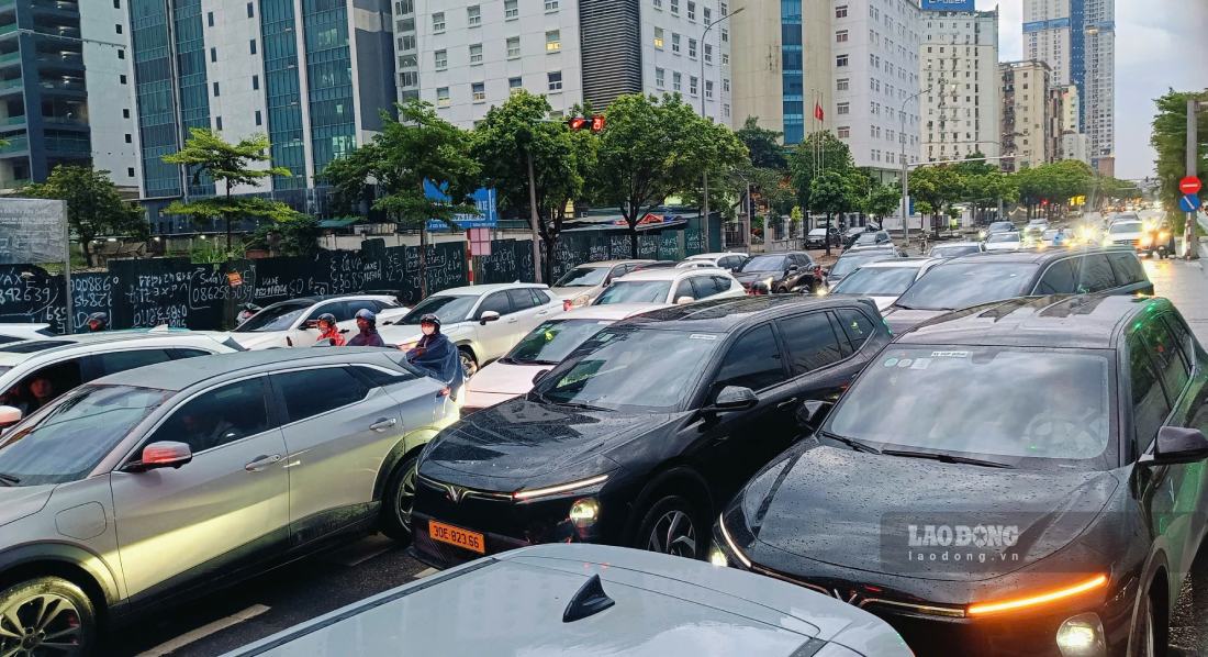 Ghi nhận lúc khoảng 18h40 ngày 8.6, tuyến đường Dương Đình Nghệ (Hà Nội) xảy ra ùn tắc kéo dài do ảnh hưởng của mưa lớn. Hàng loạt phương tiện nối đuôi nhau trên đường, di chuyển chậm hoặc gần như không thể lưu thông qua nhiều chu kỳ đèn tín hiệu.