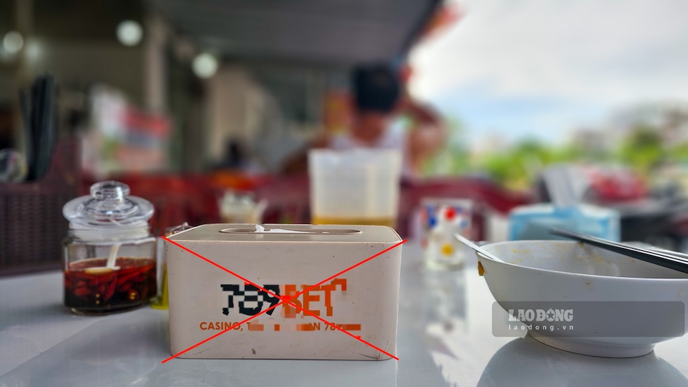 Les boîtes à lunch et les plateaux à baguettes dans de nombreux magasins du quartier de Đồng Hới, province de Quảng Trị, contiennent des logos et des codes QR menant à des sites Web de jeux de hasard déguisés. Photo: Nguyễn Luân