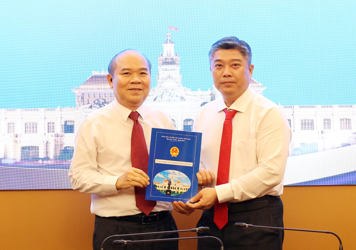 El vicepresidente del Comité Popular de la ciudad de Ho Chi Minh, Tran Van Bay (izquierda de la foto), entrega la decisión al Sr. Le Hoai Phong. Foto: Phuong Chi