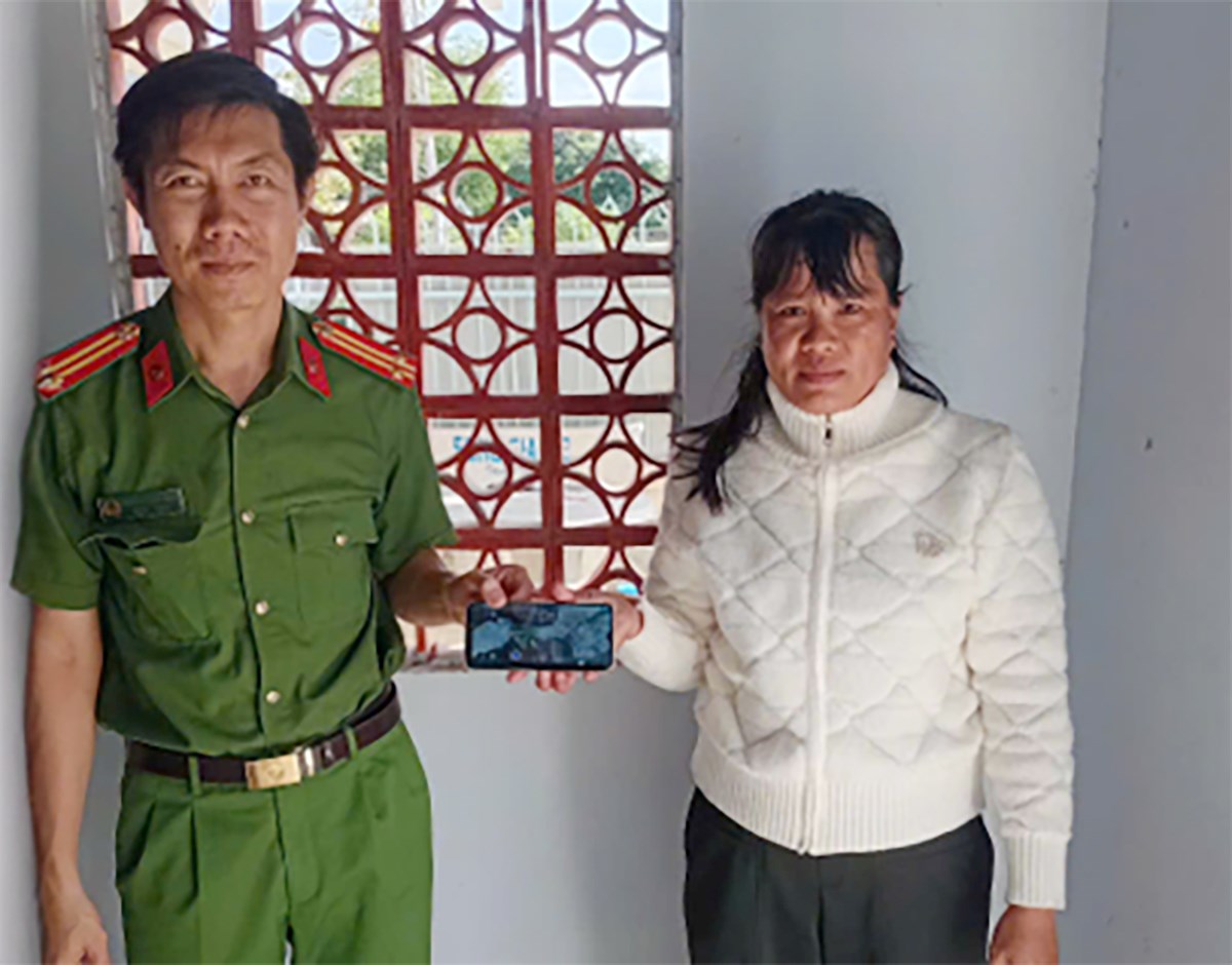 Chủ nhân nhận lại chiếc điện thoại đánh rơi. Ảnh: Công an