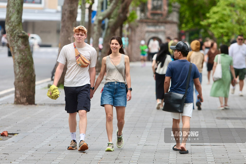 Khu vực bờ hồ Hoàn Kiếm trở thành điểm đến thu hút rất đông người dân và du khách đổ về vào giữa ngày để đi dạo, tập thể dục dưới bóng cây.