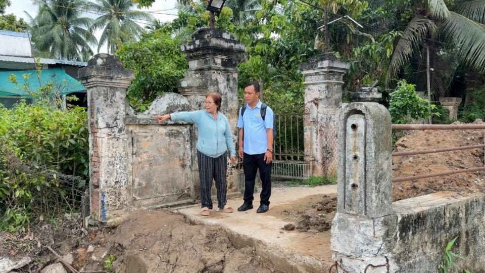 Bà Nguyễn Thị Hạnh chỉ về khu vực từng xảy ra sạt lở ven sông Giao Hòa và bày tỏ mong muốn công trình sớm hoàn thành.
