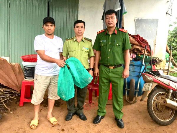 Anh Triển (bìa trái) giao nộp cá thể kỳ đà cho cơ quan chức năng. Ảnh: ĐVCC