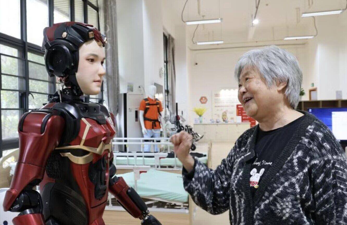 Một người lớn tuổi trò chuyện với robot hình người tên là Xia Lan. Ảnh: Xinhua.