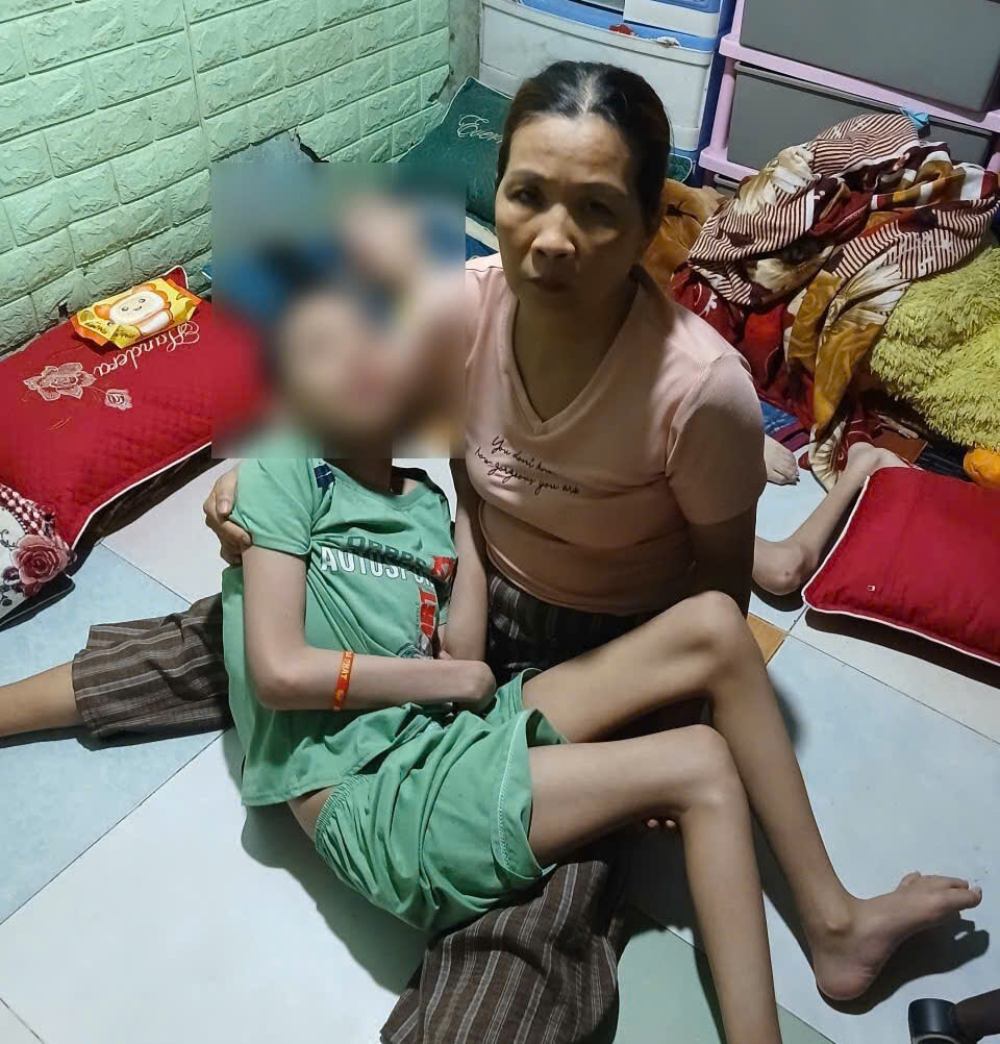 Ms. Thanh carries her son - grandson Vo Van Quan - suffering from a dangerous disease, cerebral palsy. Photo: Family provided