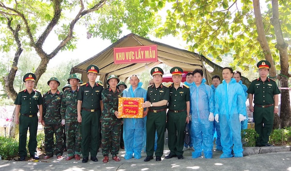 Đoàn công tác Quân khu 4 tặng quà cho các lực lượng đang thực hiện nhiệm vụ lấy mẫu ADN, số hóa thông tin tại Nghĩa trang Liệt sĩ Quốc gia Đường 9. Ảnh: Xuân Diện