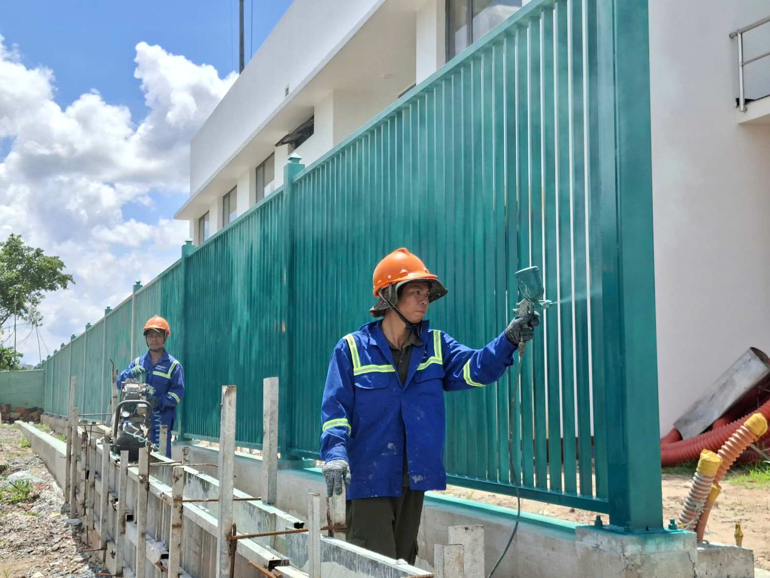 Công nhân sơn tường rào cống ngăn triều Tân Thuận.  Ảnh: Minh Quân