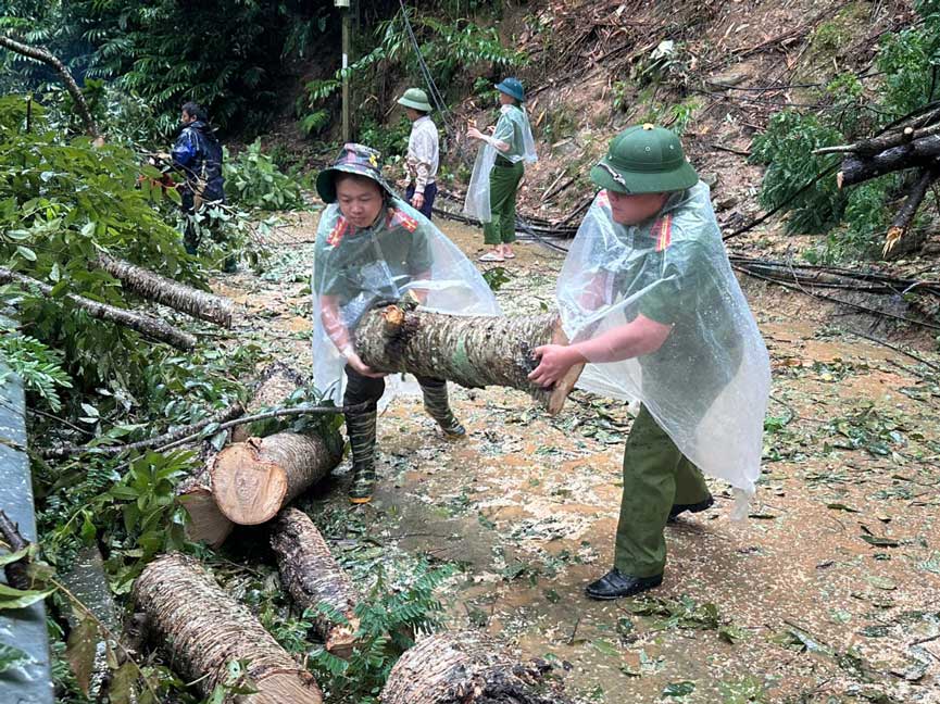 Công an xã Khao Mang phối hợp người dân dọn dẹp cây đổ sau mưa lớn. Ảnh: Công an Lào Cai