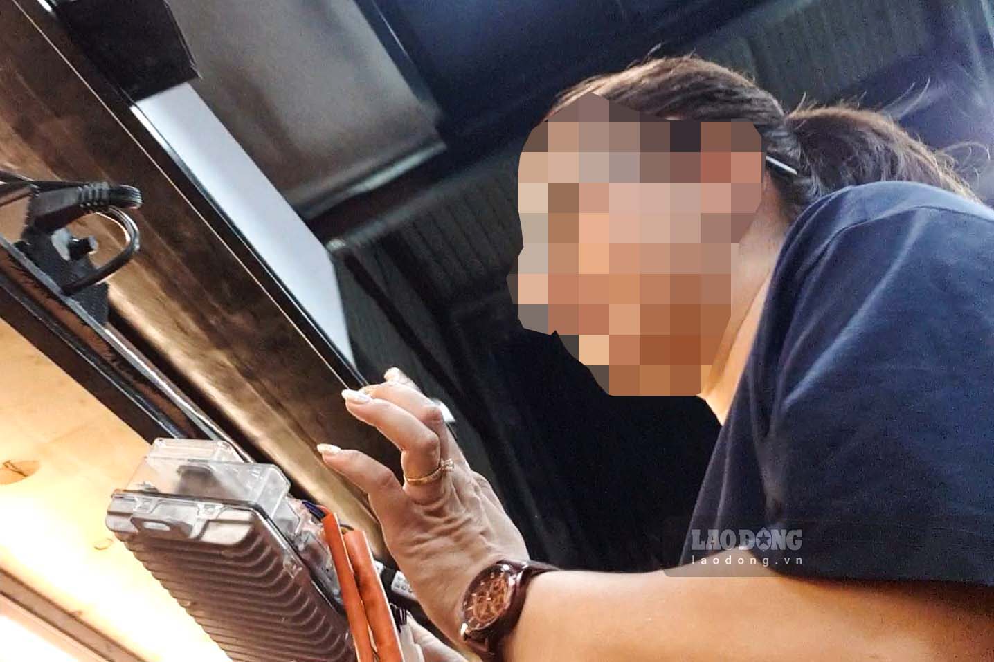 Nữ chủ chưởng độ xe máy điện cầm trên tay một bộ điều khiển điện tử (IC) để giúp xe tăng tốc độ. Ảnh: Nhóm phóng viên