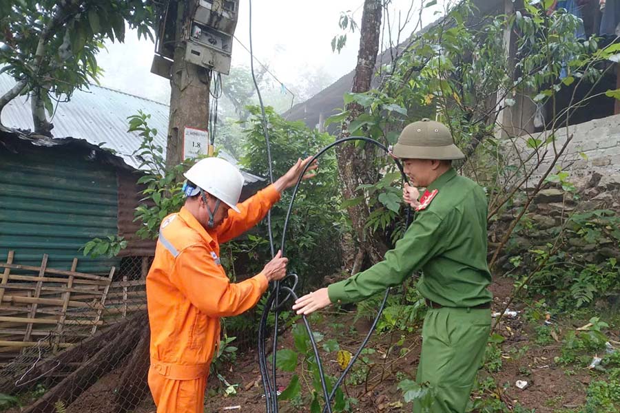 Les forces de police communales et les employés de la compagnie d'électricité de Lai Châu raccordent l'électricité après le compteur aux ménages de la région. Photo: Portail d'information électronique de la police provinciale de Lai Châu