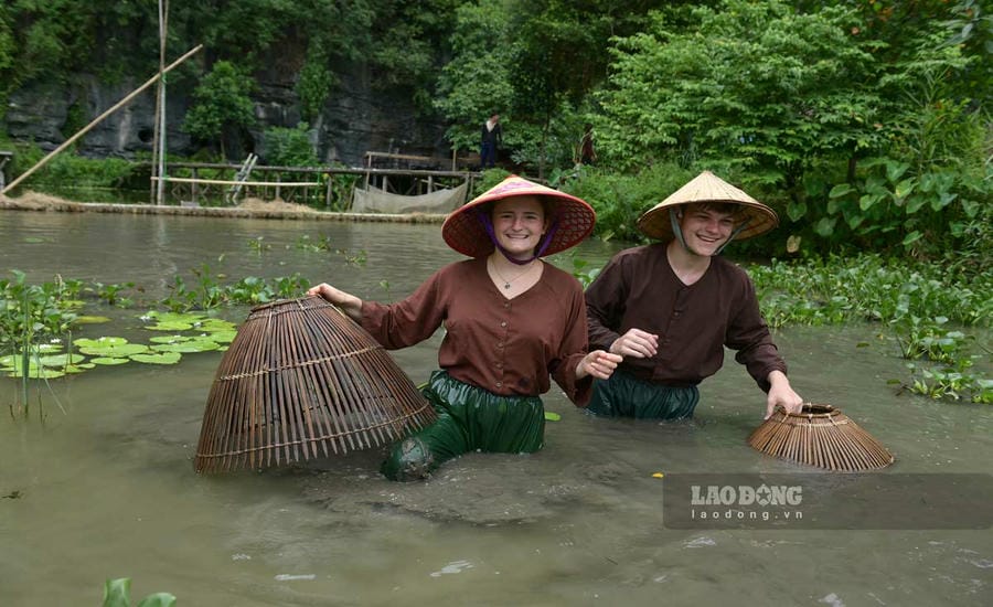 Western tourists experience agricultural tourism in Ninh Binh. Photo: Ha Vi