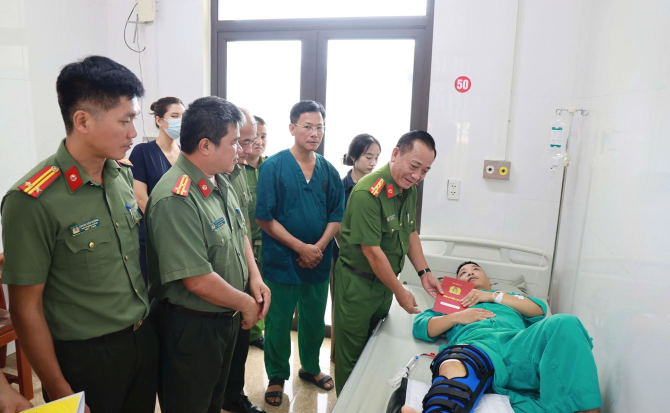 Đại tá Nguyễn Xuân Tuấn, Phó Giám đốc Công an tỉnh Lào Cai thăm hỏi, động viên Thượng úy Nguyễn Đức Khánh. Ảnh: CACC
