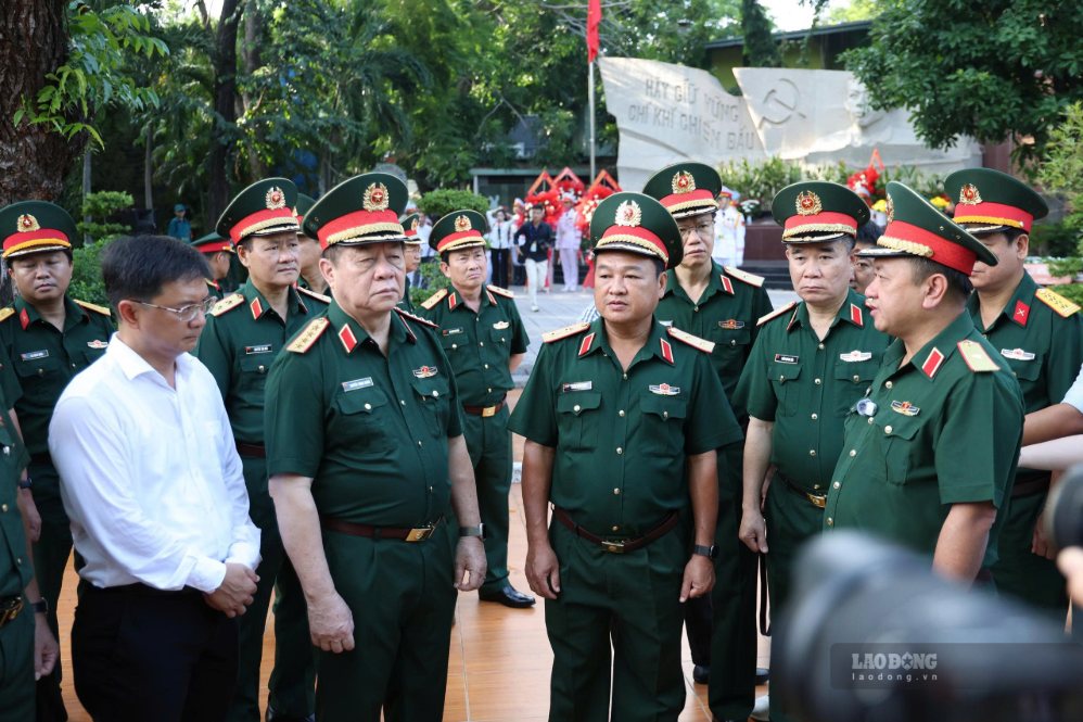 Đại tướng Nguyễn Trọng Nghĩa (thứ 2 từ trái qua) nghe báo cáo về công tác tìm kiếm hài cốt liệt sĩ tại Công viên Lê Thị Riêng. Ảnh: Anh Tú