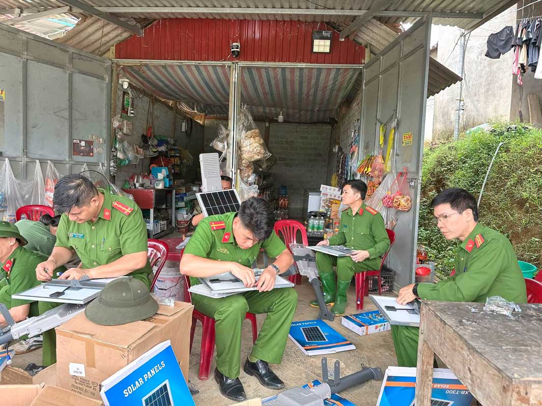 Cán bộ, chiến sĩ lắp ráp đèn năng lượng mặt trời trước khi đưa vào sử dụng. Ảnh: Công an xã Yên Bình