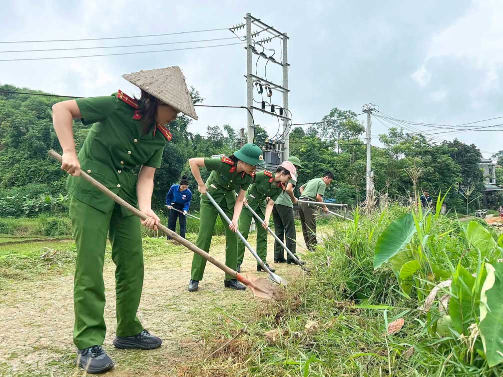 Cán bộ, chiến sĩ và đoàn viên thanh niên cùng người dân vệ sinh tuyến đường nông thôn. Ảnh: Công an xã Yên Bình