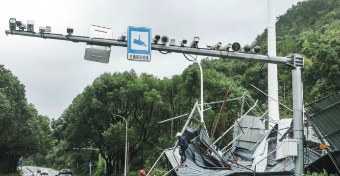 Trabajadores limpian un edificio derribado por fuertes vientos junto a una autopista en la provincia de Zhejiang, en el este de China. Foto: Xinhua