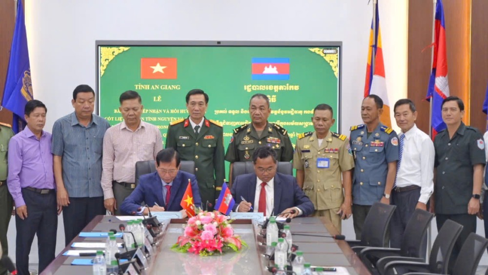 Specialized committees of 2 provinces An Giang and Ta Keo sign minutes of handover and reception of martyrs' remains. Photo: Phuong Vu/ An Giang Military Command