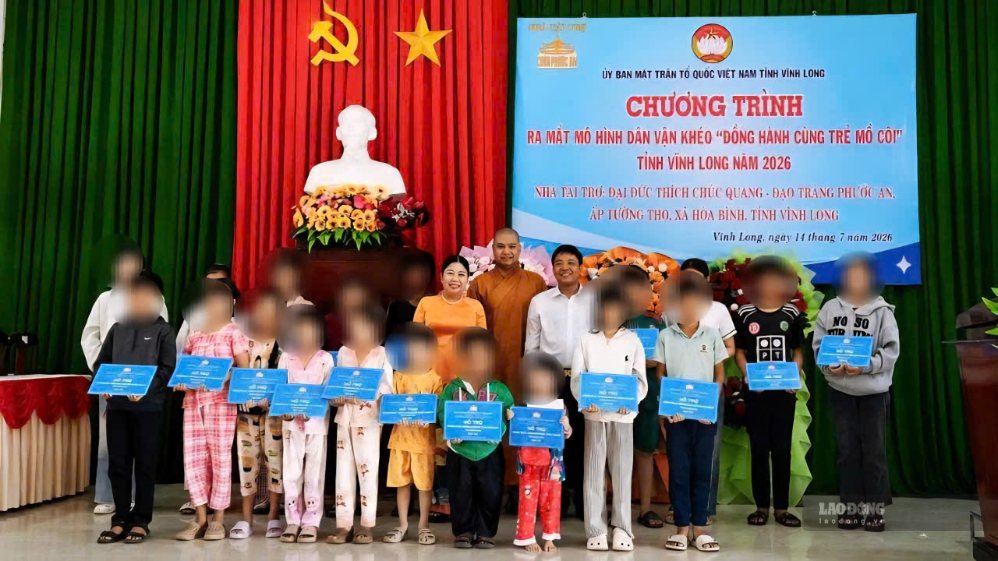 Đại diện Ủy ban MTTQ Việt Nam tỉnh Vĩnh Long và nhà tài trợ trao bảng hỗ trợ cho 20 trẻ em mồ côi có hoàn cảnh khó khăn. Ảnh: Hoàng Lộc