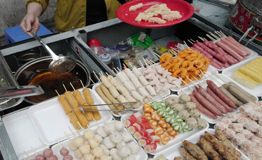 Những món quà vặt mất vệ sinh, không rõ nguồn gốc bày bán tràn lan tại các khu công cộng. Ảnh: Hà Lê