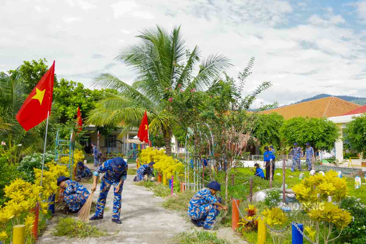 Cán bộ, học viên Học viện Hải quân cùng lực lượng địa phương vệ sinh môi trường tại Trường Mầm non Hoa Phượng. Ảnh: Trần Vương